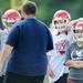 A Whitmore Lake football player rests his arm on a teammates helmet during a huddle at the school on Tuesday, August 13, 2013. Melanie Maxwell | AnnArbor.com